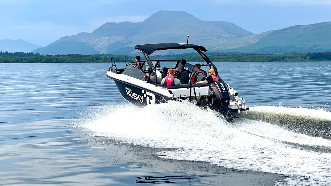 The Husky R8 speedboat cutting across Loch Lomond with a white wake behind it