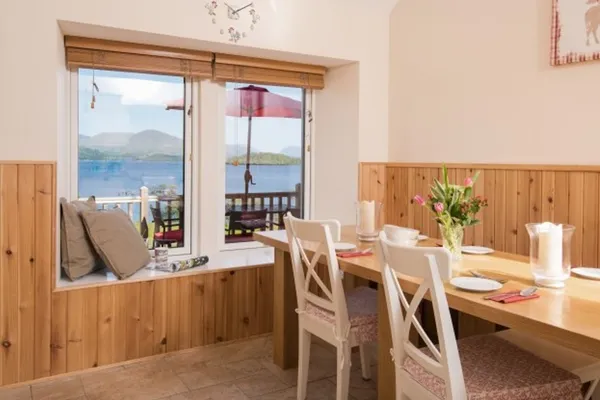 The dining table beside a window seat, with a view down to the loch